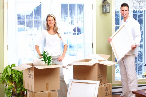 A trained mover carrying boxes with gloves and high-visibility clothing
